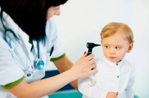 Checks a child's ear focusing on earwax removal and cleaning.