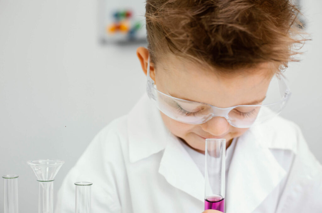  A young boy in a lab coat displays a test tube, illustrating the process of conducting on-site blood tests.