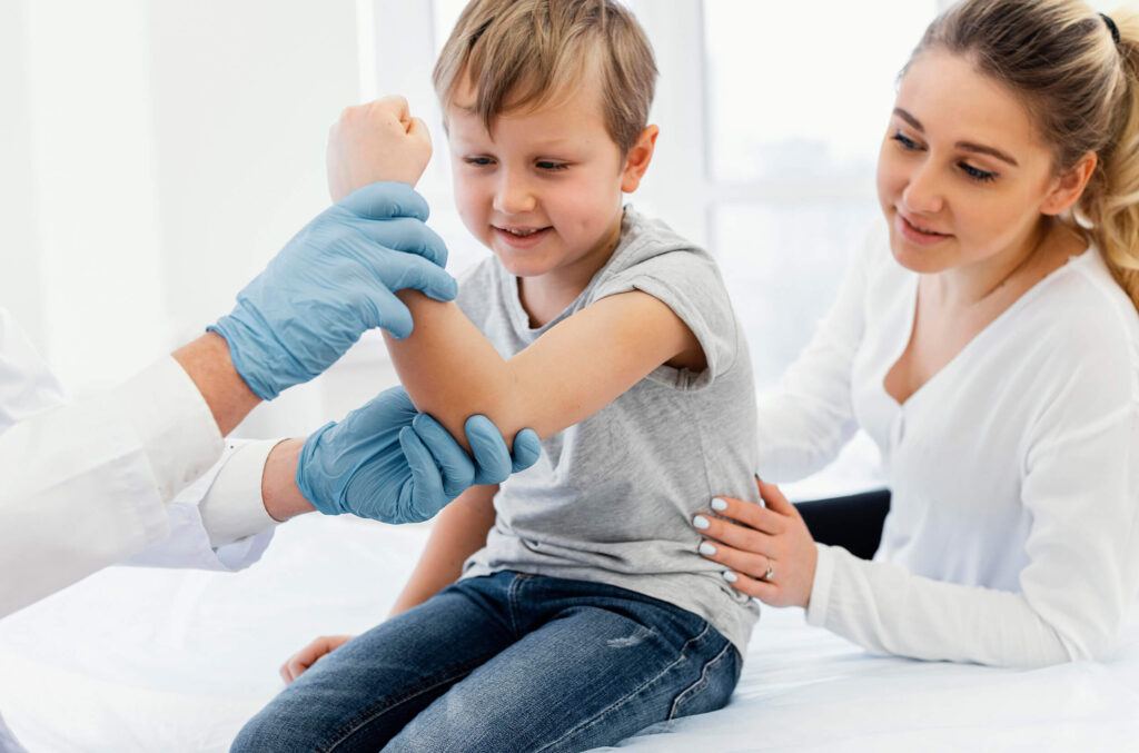 A doctor assesses a child's arm while performing an on-site blood test