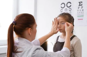 An ophthalmologist is carefully examining a child's eye, conducting a vision test to assess the child's eyesight.