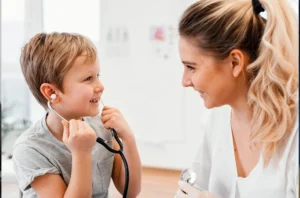 A doctor is engaging a child with a stethoscope while conducting hearing tests to evaluate the child's hearing ability.