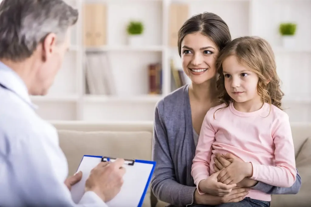  A woman and her daughter consult with a doctor on a couch about ADHD treatment options for children.