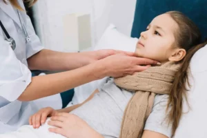 A doctor carefully examines a child's neck for signs of strep throat during a rapid strep check