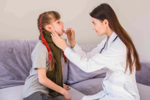 A doctor carefully examines a child's throat while performing a rapid strep throat test.