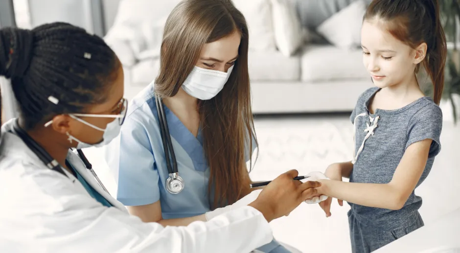 The image shows two doctors examining a child in a medical setting. The text promotes a 'Back-to-School medical checkup for children