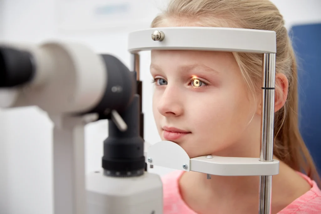 A young girl during her vision screening session with the eye exam equipment