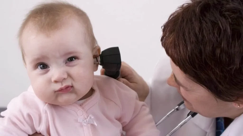 A doctor catches hearing testing equipment hearing screening for a baby.