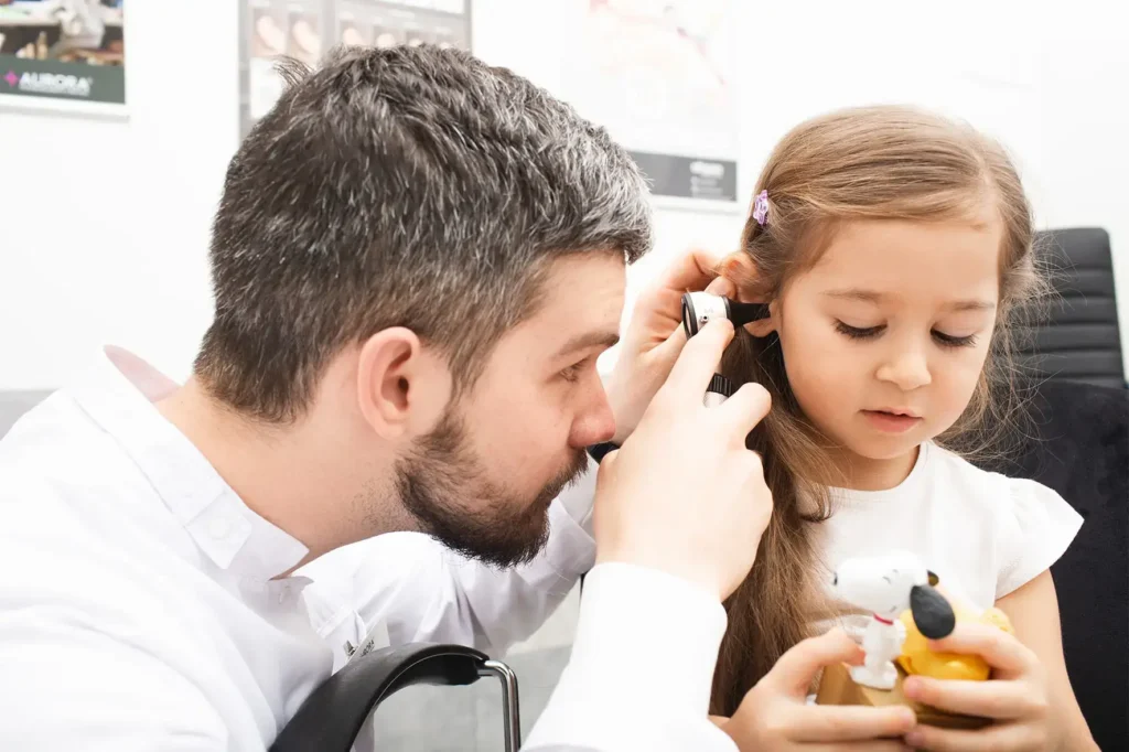 A doctor is Testing for Hearing a young girl's