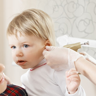 A doctor performing a safe ear piercing procedure on a young girl, ensuring comfort and care during the medical process.