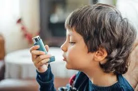 A young child using an inhaler at home, illustrating effective childhood asthma management in New Jersey.